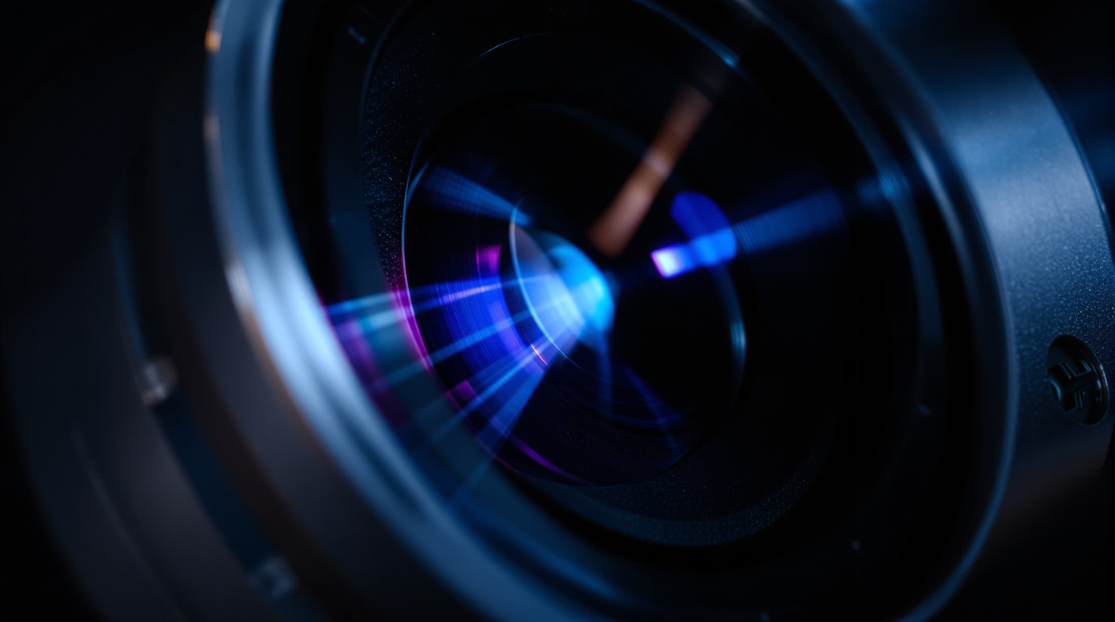 Extreme macro of the HELIX gimbal camera lens, showing a violet lens coating flare.